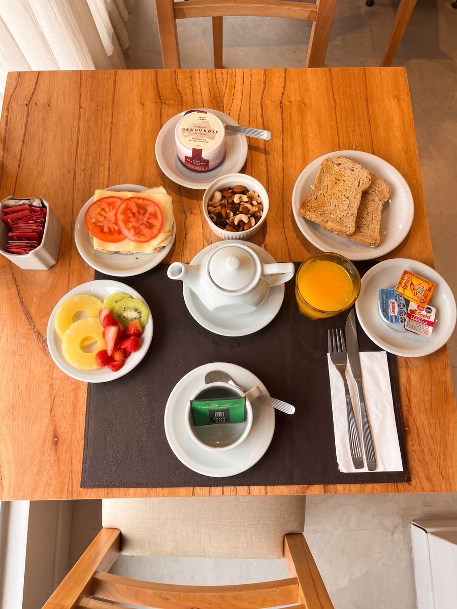 Top view of a breakfast with toast, fruit, juice and tea