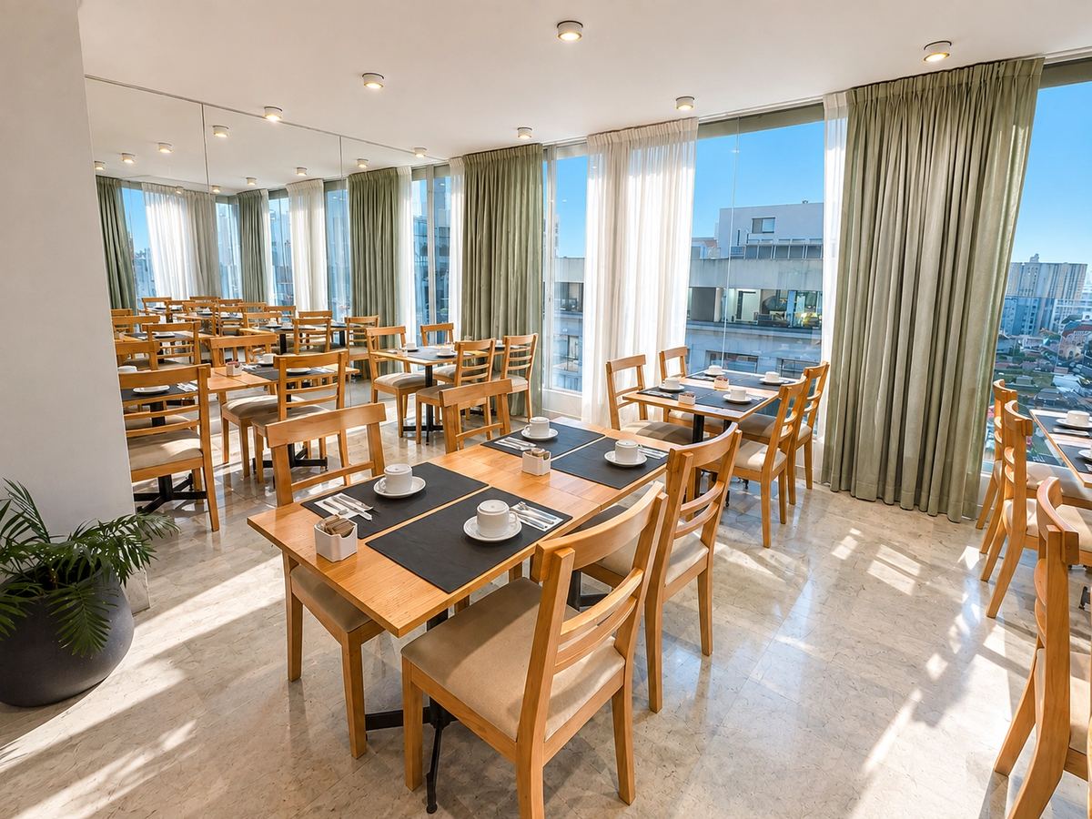 Restaurant dining room with large windows and green curtains